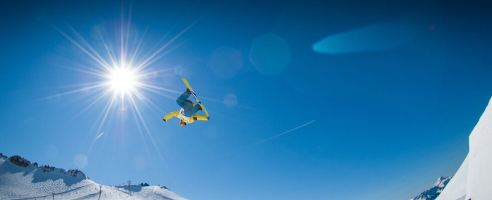 Mand der tager et hop på snowboard